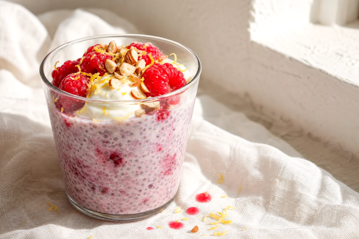 Creamy raspberry lemon chia pudding topped with yogurt, raspberries, lemon zest, and almonds