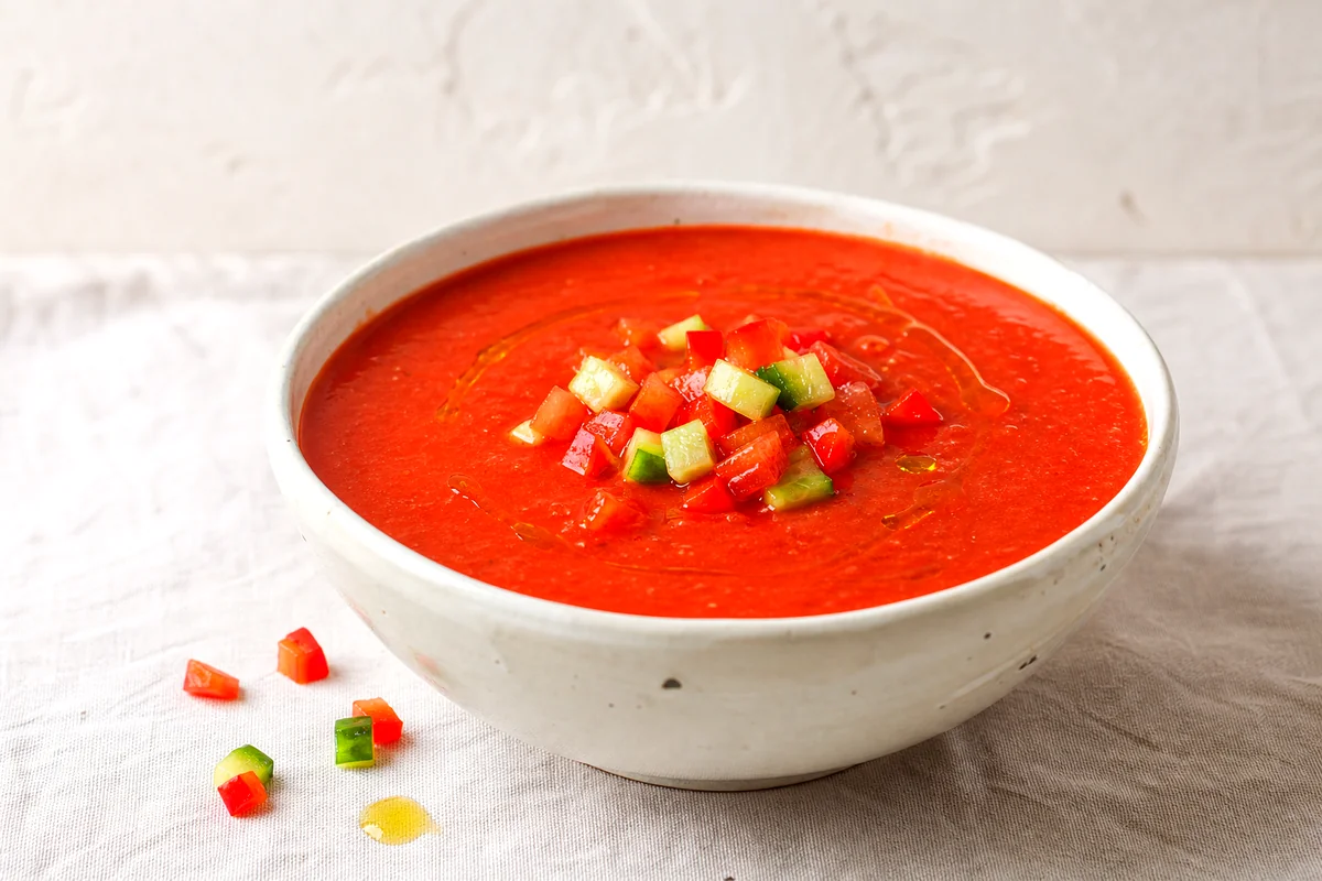 Cold Spanish gazpacho topped with diced cucumber, tomato, red pepper, and olive oil